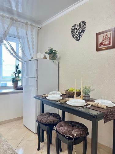 a kitchen with a table with chairs and a refrigerator at Центр. Вул. С. Крушельницької. 2 кімнати in Ternopilʼ
