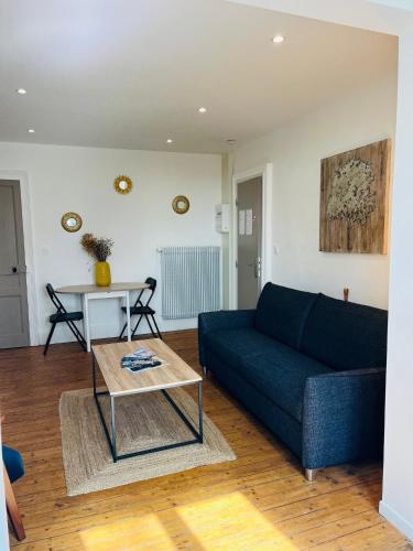 a living room with a blue couch and a table at Opal'House Face aux Remparts in Boulogne-sur-Mer