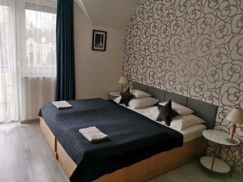 a bedroom with a bed and a wall with a pattern at Bóbita Apartman in Zalakaros