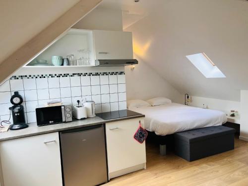 a small kitchen with a bed in a attic at Opal'House Face aux Remparts in Boulogne-sur-Mer