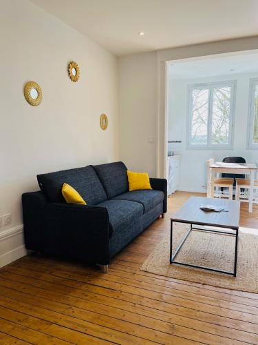 a living room with a blue couch and a table at Opal'House Face aux Remparts in Boulogne-sur-Mer