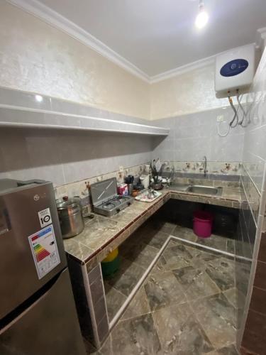 una cucina con piano di lavoro, lavandino e piano cottura di دار الياقوت Dar Al Yaqut a Dakhla