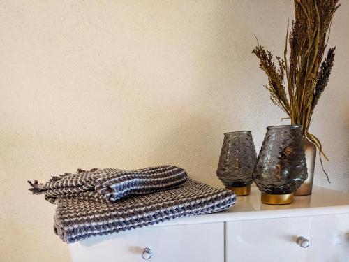 two vases sitting on top of a white dresser at Panorama Ferienwohnung Lorenzo in Gera Lario