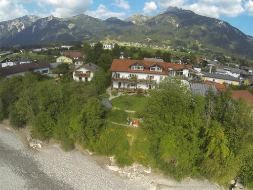 an aerial view of a house with mountains in the background at Pension beim Krümmling in Reutte