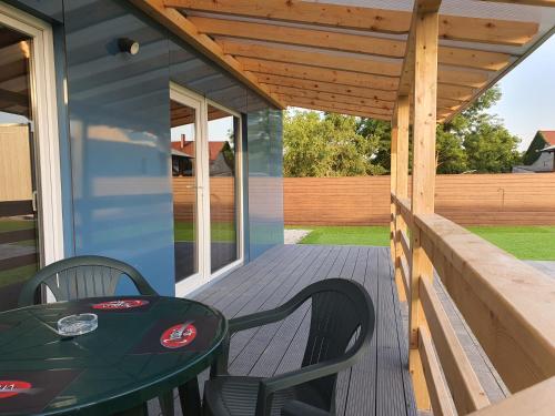 a patio with a table and chairs on a deck at Oppen-House Apartmanok in Tiszafüred