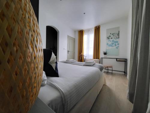 Un dormitorio con una cama grande en una habitación. en La GARE de Lamalou, en Lamalou-les-Bains