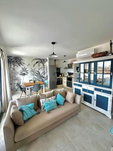 a living room with a couch with blue pillows at Appartement Casa Buisan in Argelès-sur-Mer