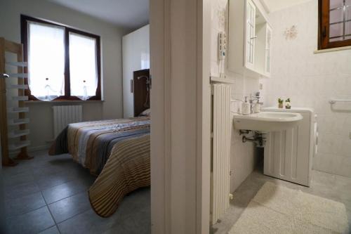 a small bedroom with a bed and a sink at Patty14 By Case al Lago in Sirmione