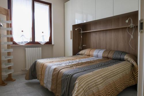 a bedroom with a bed with a wooden headboard at Patty14 By Case al Lago in Sirmione