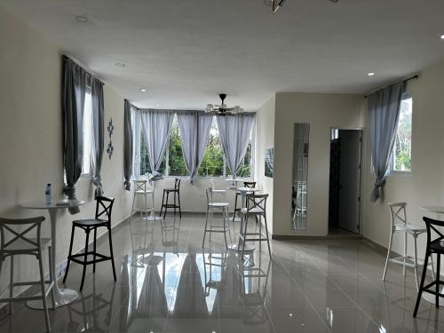 a living room with chairs and a table and windows at Hotel Mi Dulce Amanecer PyR in Nagua