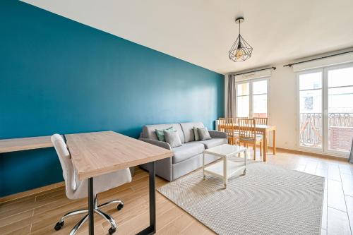 un salon avec un canapé et une table dans l'établissement Le Fantasia - Disney - Parking - Wifi, à Bussy-Saint-Georges