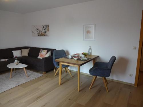 uma sala de estar com uma mesa e um sofá em Gästehaus Regina em Bad Füssing