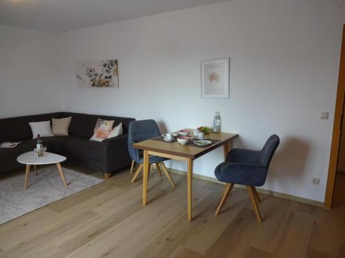 a living room with a table and a couch at Gästehaus Regina in Bad Füssing