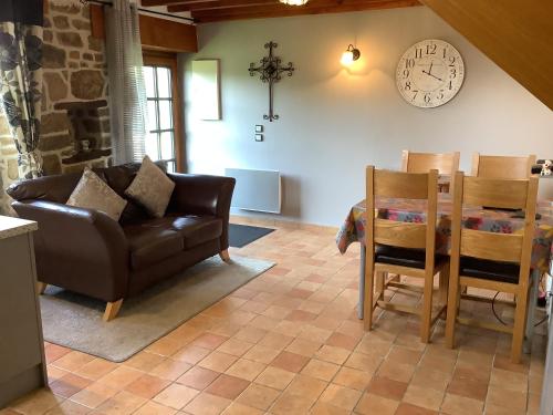 - un salon avec un canapé, une table et un réveil dans l'établissement Romantic Cottage, à Vire