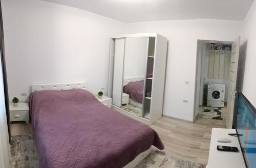 a bedroom with a purple bed and a mirror at Piano Apartament in Gura Humorului
