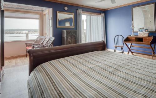 a bedroom with a bed and a desk and a window at Captains Quarters - Anchor Pier Lodge in Newport