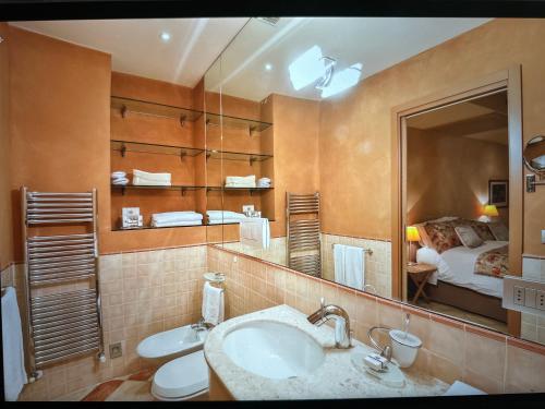 a bathroom with a sink and a mirror and a bed at Cernobbio lake suites in Cernobbio