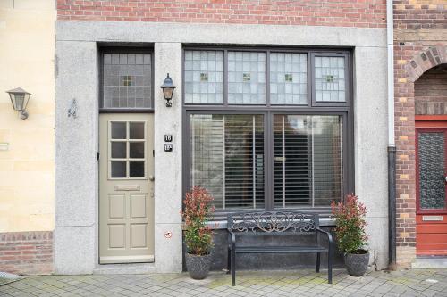 a bench in front of a building with a door at Appartement aan de Geul in Valkenburg
