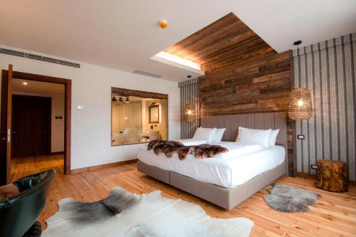 a bedroom with a large bed with a wooden wall at HANUL BUCOVINEI in Câmpulung Moldovenesc