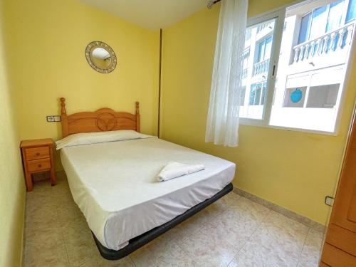 a small bedroom with a bed and a window at Apartamentos Costa Azahar 3000 in Alcossebre