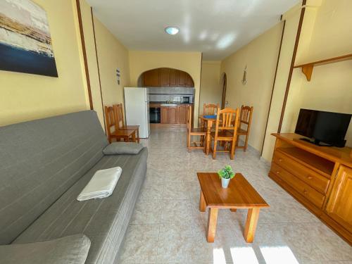 a living room with a couch and a table at Apartamentos Costa Azahar 3000 in Alcossebre