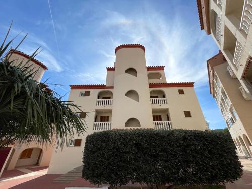 a building with a tower on top of it at Apartamentos Costa Azahar 3000 in Alcossebre