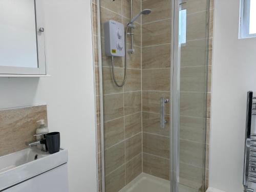 y baño con ducha y puerta de cristal. en Cosy Modern 2 Bedroom Apartment bedroom with ensuite bathroom - Neath Road Port Talbot Near Briton Ferry Train Station, en Briton Ferry