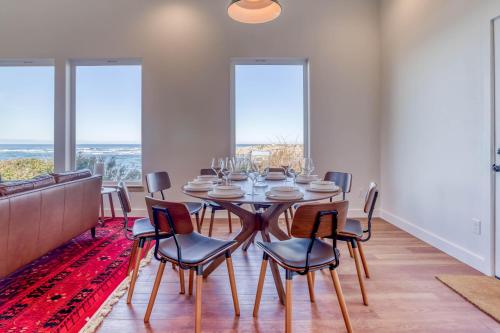 a dining room with a table and chairs and windows at Walters Waldport in Waldport