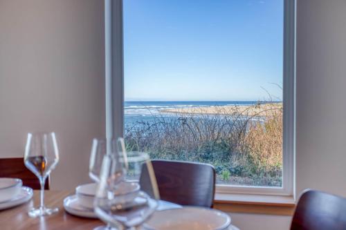 a table with wine glasses and a view of the ocean at Walters Waldport in Waldport