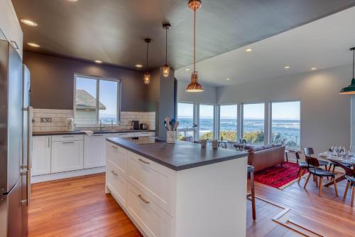 a kitchen with white cabinets and a dining room with a table at Walters Waldport in Waldport