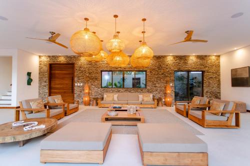 uma sala de estar com sofás e mesas em Aldeia Jericoacoara - Suites Privativas em Jericoacoara
