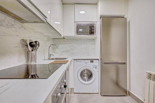 a kitchen with a refrigerator and a washing machine at La paz home by Clabao in Logroño