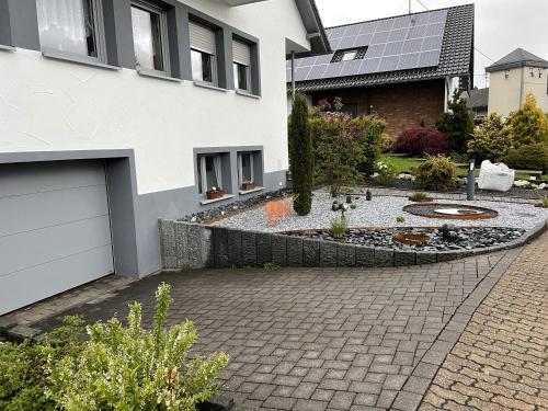 une maison avec un jardin en face d'une allée dans l'établissement Ferienwohnung Waldeck, à Mitlosheim