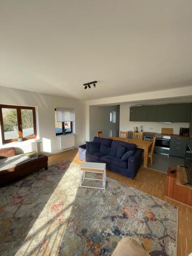 a living room with a blue couch and a table at Haus Charlottenburg 3, zentrumsnah gelegen, mit Blick auf die Festung, mit Sauna Option in Königstein an der Elbe