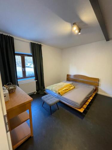 a room with a bed and a table and a desk at Haus Charlottenburg, zentrumsnah gelegen, mit Blick auf die Festung, ab April 24 mit Sauna Option in Königstein an der Elbe