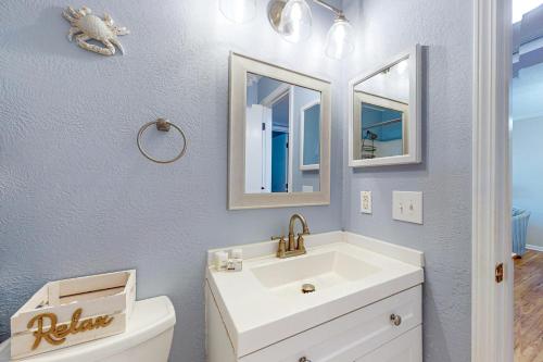 ein Bad mit einem Waschbecken, einem WC und Spiegeln in der Unterkunft Sea Cabin 214 in Myrtle Beach