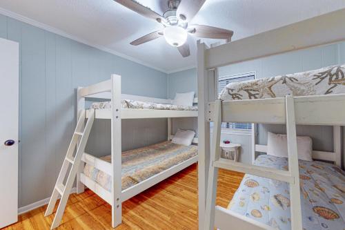 1 Schlafzimmer mit 2 Etagenbetten und einem Deckenventilator in der Unterkunft Sea Cabin 214 in Myrtle Beach