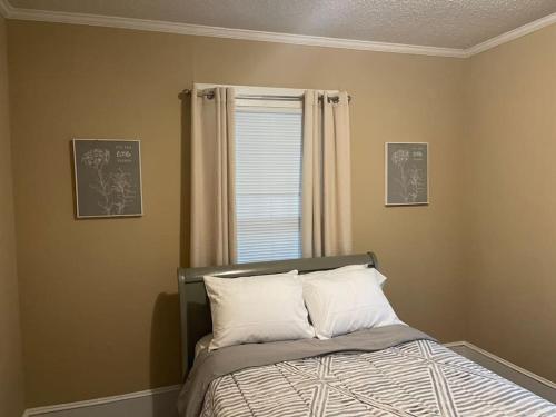 Bett in einem Zimmer mit einem Fenster und einem Bett sidx sidx sidx sidx in der Unterkunft Historic Charmer, Pet-friendly in Concord