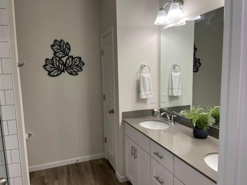 baño con 2 lavabos y espejo grande en Embrace the Harmony of Nature and Urban Living, en Concord