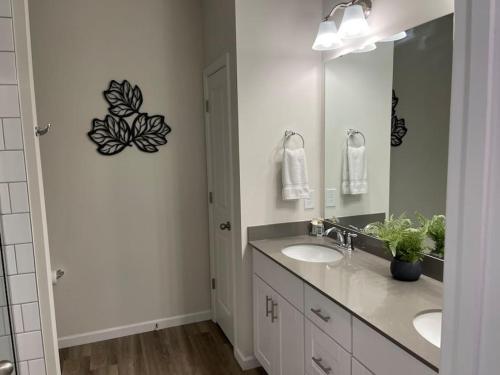 a bathroom with two sinks and a large mirror at Embrace the Harmony of Nature and Urban Living in Concord