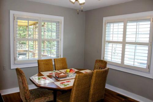 a dining room with a table and chairs and two windows at The Bailey Hot Springs in Hot Springs