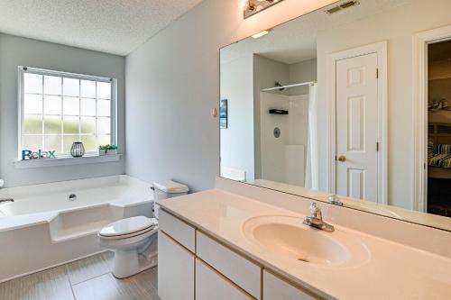 a bathroom with a sink and a toilet and a mirror at Murrells Inlet Condo with Pool Access, Near Beach! in Myrtle Beach