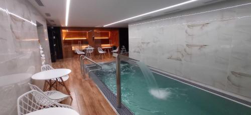 a hot tub in a room with a table and chairs at Boutique hotel & Wellness Spitzerova vila Eliška in Janovice