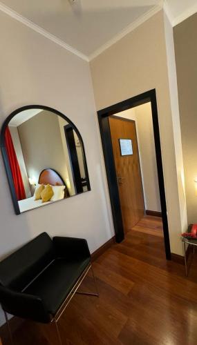 a room with a mirror and a chair and a door at Delle Nazioni Milan Hotel in Milan
