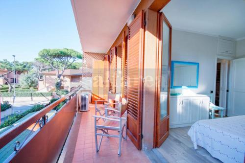 a room with a balcony with a bed and a television at Mare appartamento ristrutturato e con posto auto in Castiglione della Pescaia