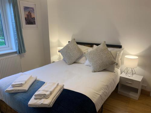 a bedroom with a bed with two towels on it at New Modern house in Reading with free parking in Caversham
