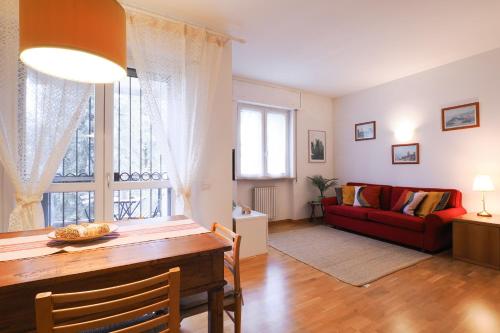 uma sala de estar com uma mesa e um sofá vermelho em PrimoPiano - Buccinasco em Buccinasco