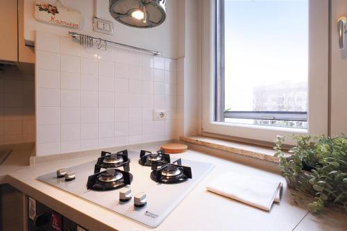 uma cozinha com fogão forno superior ao lado de uma janela em PrimoPiano - Buccinasco em Buccinasco