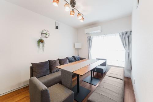 a living room with a couch and a table at City House 暁 -akatsuki- in Osaka
