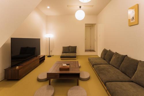 a living room with a couch and a tv at City House 暁 -akatsuki- in Osaka